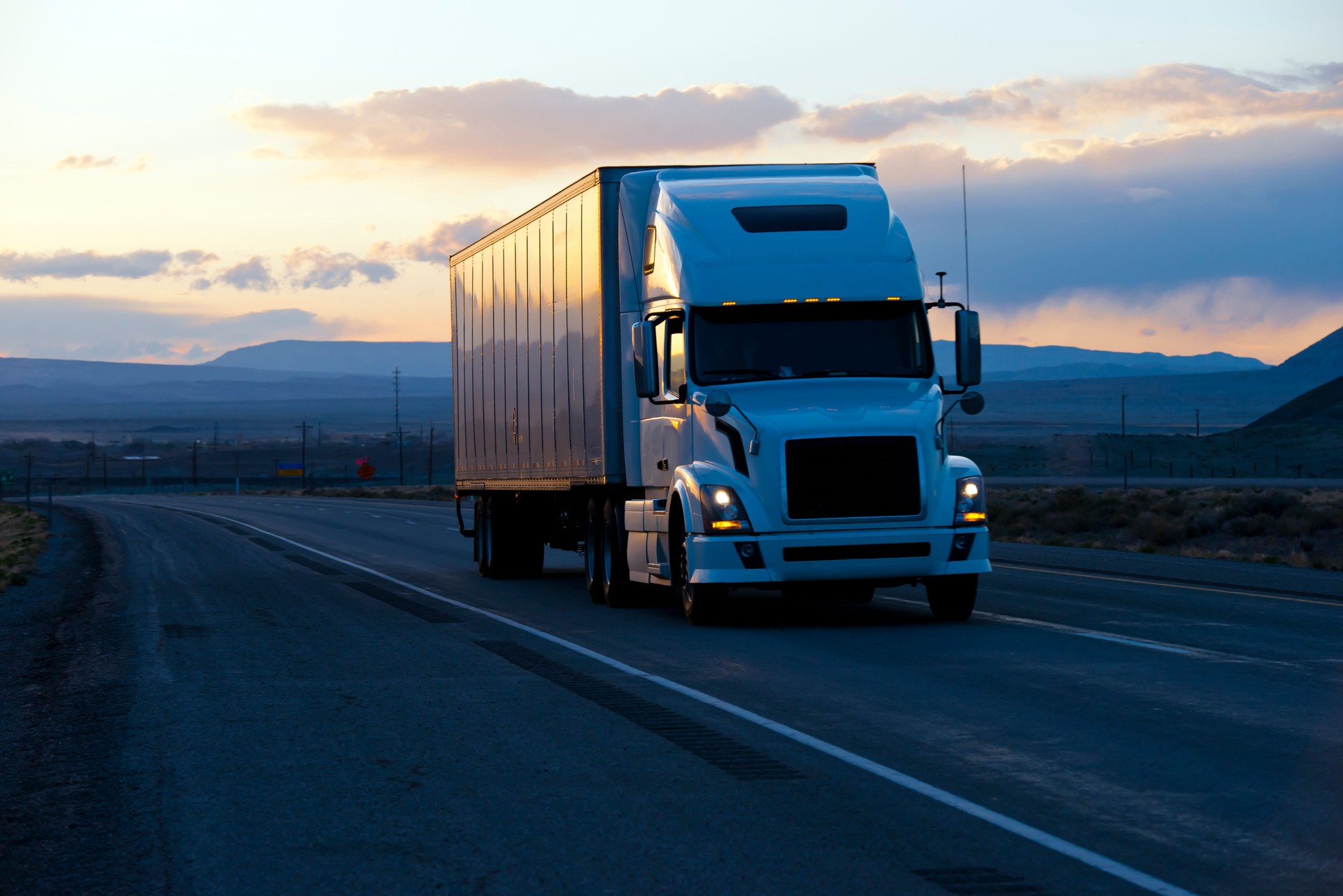 Modern semi truck trailer on twilight highway