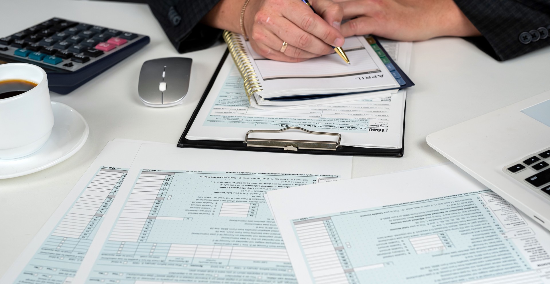 close up of male hand filling US tax form. Accountant working with 1040 form